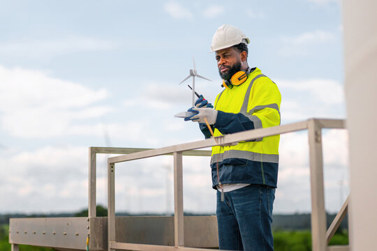man in  yellow safety vest is standing on  metal platform - Powered by Adobe