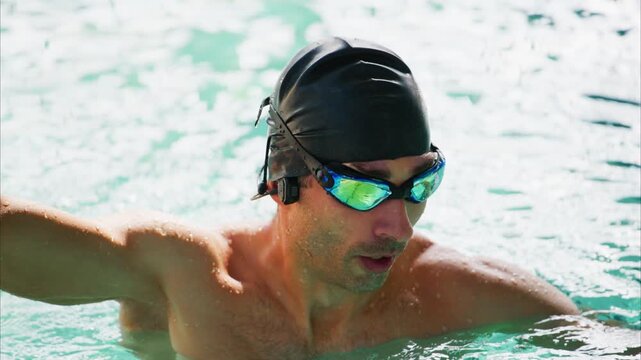 Intense Swim Training Session: A Focused Swimmer Adjusts Gear in the Water, Demonstrating Commitment and Athleticism While Preparing for Performance Enhancement.