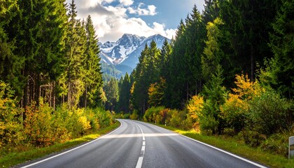 Fototapeta premium Scenic Road Through Forest Leading to Distant Mountains.
