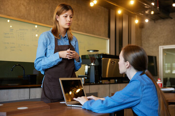 young barista meeting and talking about work in the cafe