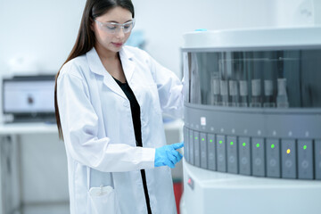 A clinical laboratory scientist loads a sample rack onto a high-throughput chemistry analyzer. The...