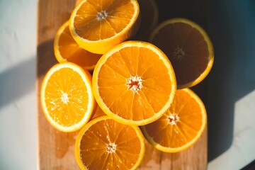 Freshly Sliced Ripe Oranges Displayed on a Wooden Cutting Board Bathed in Warm Sunlight Creating Inviting Shadows