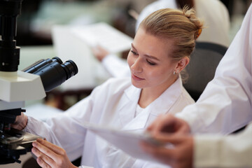 A biotech engineer uses an advanced digital microscope with AI powered image analysis to observe cellular changes in real time, pioneering new gene therapies or designing novel biomaterials.