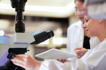 Two pathologists engage in a peer consultation, cross-referencing microscopic findings with patient data to finalize a complex histopathology report for an oncology case.