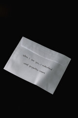 A white envelope with a handwritten message on it. The message reads, 