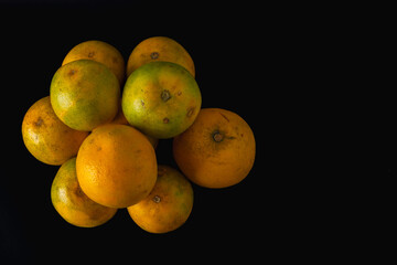 A pile of fresh oranges of varying sizes and shades, stacked together in a natural arrangement. Vibrant citrus fruit concept symbolizing freshness, nutrition, harvest, and healthy eating.