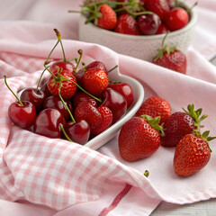 a close up shot of ripe cherries and strawberries