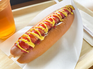 トマトケチャップとマスタードソースをトッピングしたジューシーなホットドッグ。
