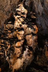 A close-up shot reveals the fascinating geological formations within a cave. Textures, shadows, and colors create a captivating scene