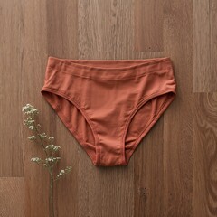 Sustainable fashion flat lay of organic cotton women's underwear mockup on a wooden background.