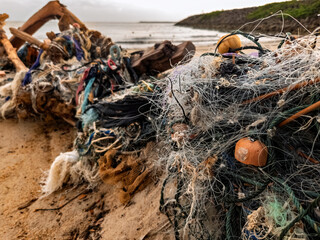  Trash on the beach, including fishing lines and other debris washed up by the tides.