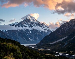 Mountain range with snow-capped peak at sunset, a river and a lake