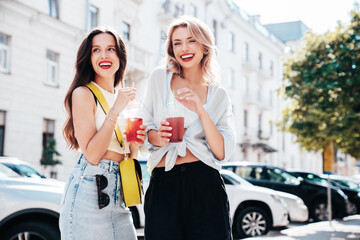 Two young beautiful smiling glam female in trendy summer clothes. Sexy women posing outdoors....