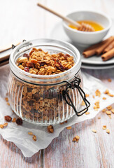 Homemade honey granola in jar with cinnamon sticks