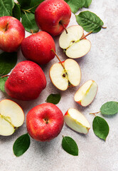 Fresh red apples with green leaves on grey background