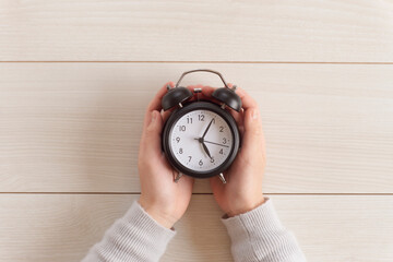 Child's hands holding a clock. Children's time, time management, study time, learning time, schedule, planning, etc.  時計を持つ子供の手。子供の時間、時間管理、勉強時間、学習時間、スケジュール、計画など