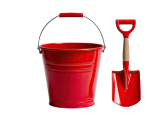 A shiny red bucket with a metal handle sits next to a matching red shovel, both isolated