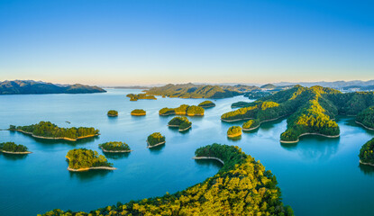 Aerial view of the beautiful lake and green islands with mountain natural landscape at sunrise. Famous Qiandao Lake scenery in Hangzhou, China.