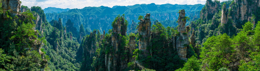Fototapeta premium Majestic Zhangjiajie national forest park: towering sandstone pillars emerging from lush green forest, Wulingyuan Scenic Area, Hunan Province, China.
