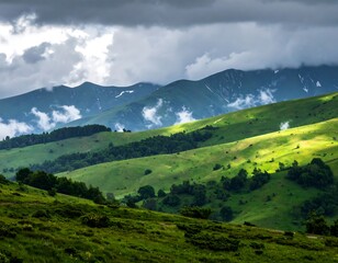 Fototapeta premium Rolling green hills meet mountain range under stormy sky