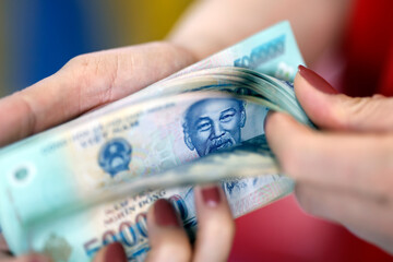 Shopkeeper counting Vietnamese dong bills. Ho Chi Minh city. Vietnam.
