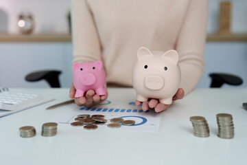 Financial Management. Woman comparing piggy banks and coins, illustrating savings strategies.