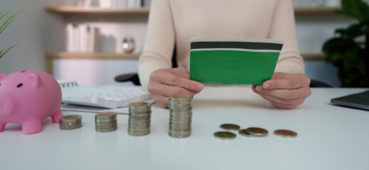 Financial Awareness. Holding a green wallet with coins on a desk.