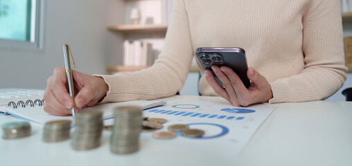 Financial management. Analyzing expenses with a smartphone and notebook.
