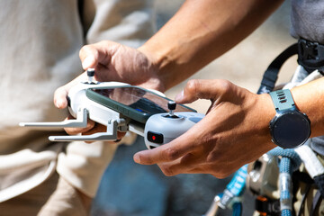 Hands operating drone controller outdoors