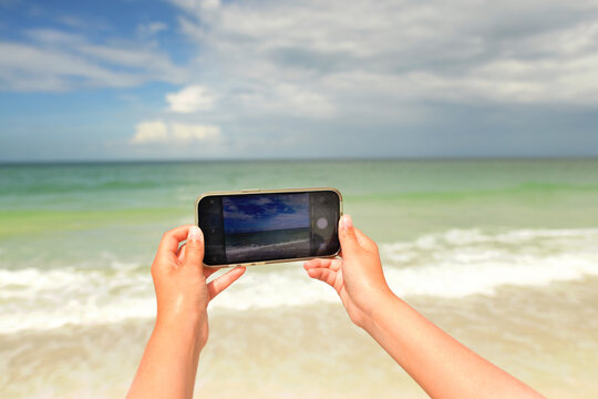 Up close young hands holding cell phone photography tropical bea