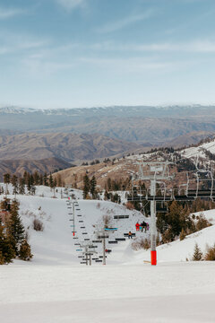 Ski lift carrying skiers up snowy mountain