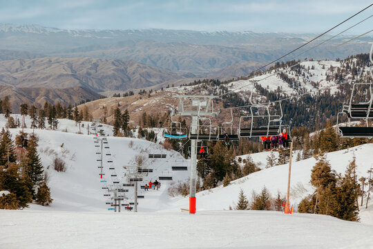 Ski lift travelling up snowy mountain slope