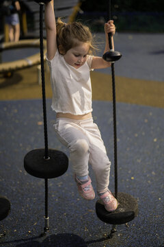 Little girl climbing, playing and having fun at playground