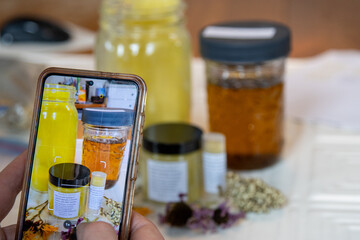 Woman photographs herbal salve products for marketing