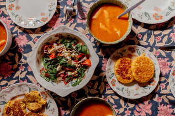 Cozy dinner table with soup, salad, and fried patties