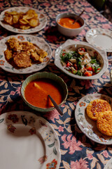 Cozy dinner table with soup, salad, and fried patties