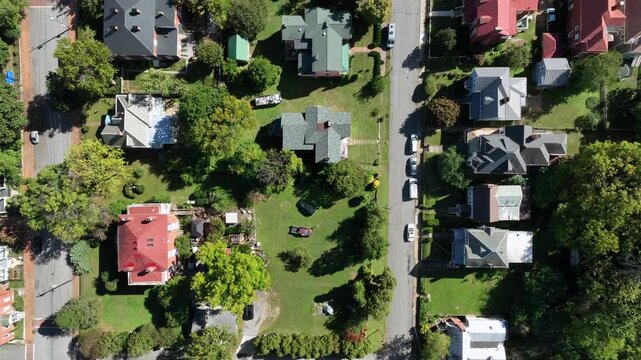 Row of houses with green grass in garden at sunny autumnal day in usa. Aerial top down flyover. Peaceful and quiet suburb neighborhood in america.