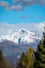 Beautiful orange and red autumn forest and snowy mountains
