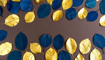 A decorative arrangement of gold and navy blue leaves on a dark brown surface creates a sophisticated and elegant aesthetic.