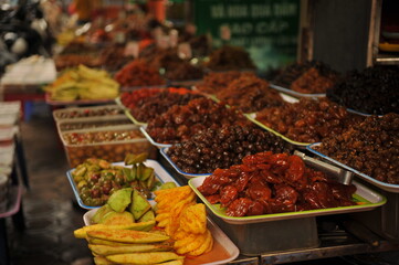 Display of dried nuts and fruits for sale at local market in Vietnam.