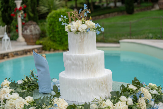 Stunning multi-tiered wedding cake centerpiece at festive wedding celebration with joyful guests
