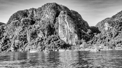 Fototapeta premium Phi Phi Island, Thailand - December 24, 2019: Long-tail boats and speedboats lined up along the turquoise shores of Phi Phi