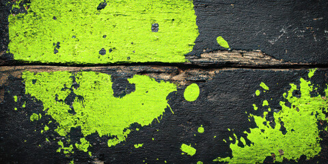 Vibrant Neon Green Paint Splatter on Distressed Black Wooden Surface