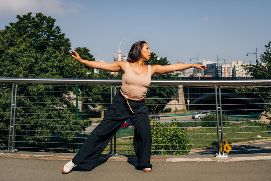 Female dancer performing urban contemporary movement on bridge