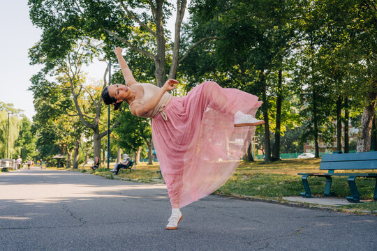 Female dancer gracefully posing, expressing freedom in park