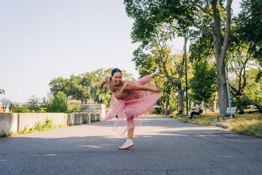 Woman dancing ballet in park feeling joy and freedom