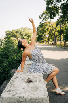 Woman dancing freestyle expressing freedom in urban park light