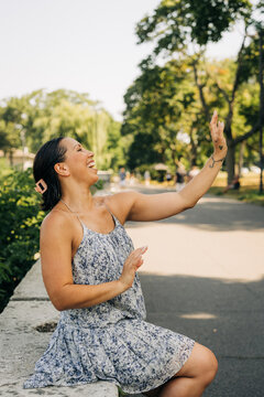 Woman laughing outdoors, enjoying summer day park