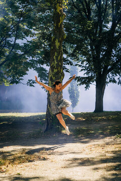 Woman jumping dancing expressing freedom in nature park