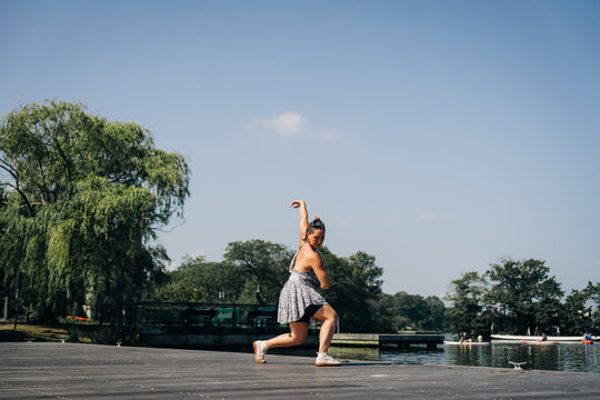 Woman dancing contemporary movement outdoors on a pier